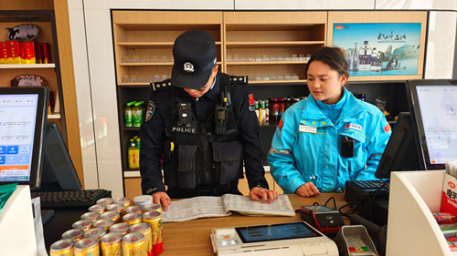 图为民警对加油站台账记录进行检查.jpg