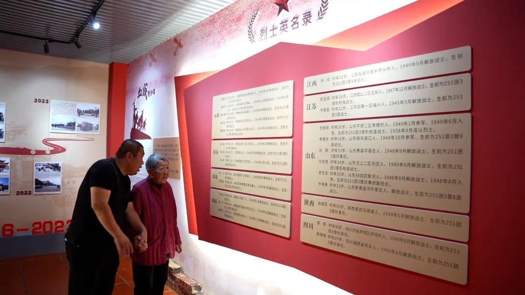 纪念馆登记了解放军庙供奉的27名名录，图为张凯陪奶奶重温名单。杜志鑫摄